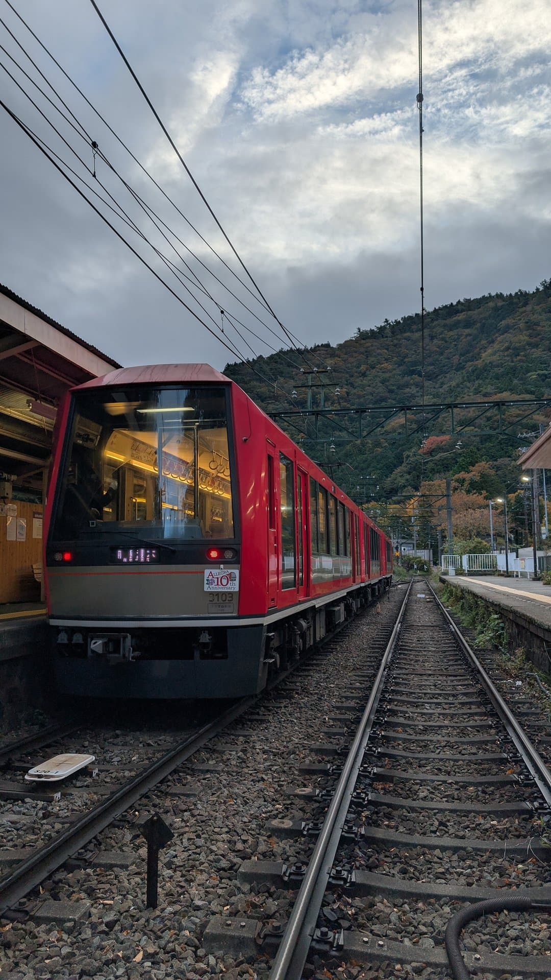A red Hakone Tozan Railway train at a mountain station in November