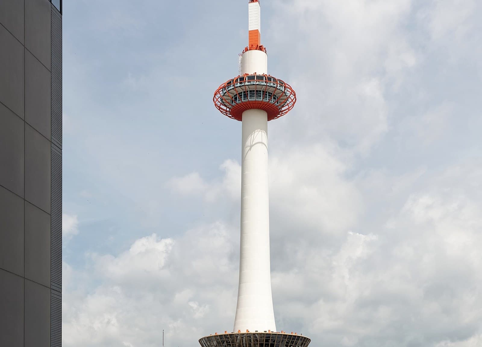Kyoto Tower rising beside Kyoto Station — station-area hotel rooftop context for Tokyu