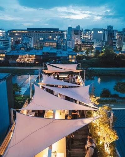 UE rooftop over the Kamo River — white sail canopies and blue-hour Kawaramachi lights