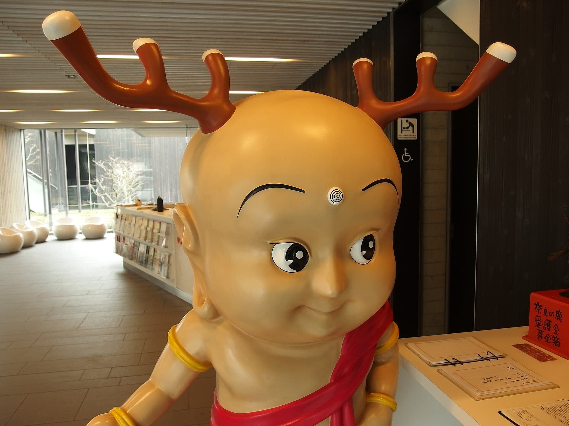 A close-up statue of Sento-kun, a mascot combining a Buddhist child monk with deer antlers, on display in Nara